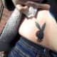 A black Playboy bunny tattoo on the hip.
