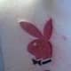 A pink Playboy bunny with an initial.
