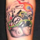 An eight ball tattoo on the forearm with other gambling items.