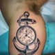 Pocket watch tattoo with an anchor.