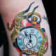 Pocket watch tattoo with the text, &quot;Time heals nothing.&quot;