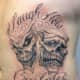 The masks have a skeletal appearance in this tattoo.