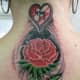 This rose tattoo design includes a heart with Hebrew characters inside.