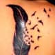 Feather tattoo that incorporates birds.