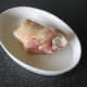 Pork shank is laid on ovenproof tray and seasoned