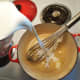 Add the milk and cream quickly and whisk continually. At this point you can turn up the heat to medium.