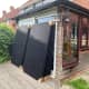 Solar panels delivered and stacked against our conservatory door prior to the erection of the scaffolding for installing them.