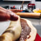 Starting at the long edge, tightly roll up each dough square jelly-roll style into a tight log. Repeat with the second piece of dough and remaining chocolate sauce.