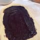 Using a spatula or a knife, spread the chocolate filling in an even layer over the dough square.