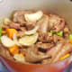 Browned meat is readded to the pot and stirred in with the vegetables