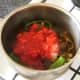 Canned tomatoes are added to spiced mutton and vegetables