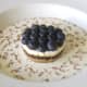 Blueberry and Christmas pudding cheesecake is served in cream and chocolate bath