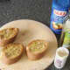 Extra virgin olive oil, sea salt and black pepper are added to garlic toast