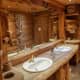 A wooden bathroom with wooden sinks has a ranch feel to it. I would add yellow flowers and other decorations to give it a more charming feel.