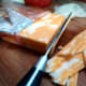 Utility knife slicing a brick of cheese