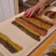 You'll probably need about four cutting boards or work surfaces to make the striped doughs. I also recommend putting the new stripes on a plastic-covered surface. It will make life easier.