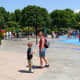 The author and her son walk by the splash pad in Duplo Village.