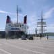 Mainland ferry docked beside tall sailing ship at Port Ellen