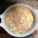 The cheesy potato mixture has been poured in a casserole dish. Cheese and crushed potato chips have been added and the dish will now be baked in my oven