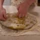 After the first rise, mix together equal amounts of bread flour and semolina flour and spread them on a clean surface area. Press the dough down into the flour.