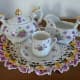 Dainty violet tea set with 22 carat gold trim on hand-crocheted doily