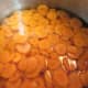 Boiling carrots in water until tender