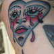 Traditional heart with a crying face tattoo