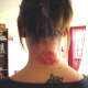 All-red lotus tattoo on back of neck