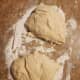 Place the risen dough on a floured surface. Cut the dough in half using a dough cutter.