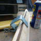 Using a small clamp to hold a small piece of scrap wood on the underside to create an angle (slope) when laid on a flat surface