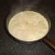 Parmesan cheese flakes are scattered over scalloped potatoes
