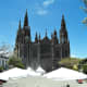 The shaded tables of Cafe el Parque with Iglesia de San Juan Bautista in the background.