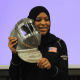 Ibtihaj Muhammad holding a fencing helmet