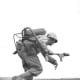 A flamethrower operator of E Company, 2nd Battalion 9th Marines, 3rd Marine Division, runs under fire on Iwo Jima. Flamethrowers were used to break up Japanese strong points.