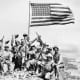 American troops celebrate the capture of Mount Suribachi. But the Japanese still held a strong position and the bloodiest fighting was yet to take place.