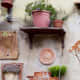 Try hanging shelves from the wall (and each other) and place plants on top. You could also hang a plant underneath the bottom shelf.