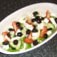 Feta cheese and black olives are added to the salad