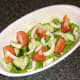 Tomato, cucumber and fennel is laid on top of the lettuce