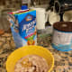 Put measured oats, Malt-O-Meal, peanut butter, sweetener, almond milk, and Ovaltine in a tall-sided bowl.