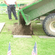 Another trailer full of the dirt saved when the hole was dug is now dumping the dirt back.