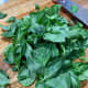 On a cutting board, roughly chop the fresh basil.