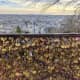 Love locks at the feet of the Basilica of the Sacred Heart, Montmartre with a view of Paris city.