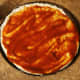 Spread 3/4 of the pizza sauce as evenly as possible.
