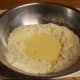 Make a hole in the middle of the flour mixture, and add the egg mixture into it. Combine the ingredients together with your hands.