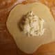 Place about 2 tablespoons of the cheese into the center of each empanada disc. For a sweeter flavor, sprinkle about 1/2 teaspoon sugar on top of the cheese.