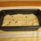 Pour the batter into the greased loaf pan. Gently even off the surface.