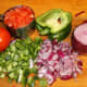 Chop the tomatoes, green bell pepper, and red onion and add them to the salad bowl.