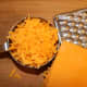 Grate and measure the cheddar cheese and add it to the salad.