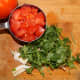 Chop and measure the tomato, cilantro, and garlic cloves. Place them in the blender.