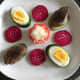 Pigeon breasts and duck egg halves are balanced on cucumber slices